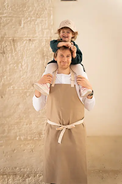 Maxime, cofondateur de Pleincœur, portant sa fille Hortense sur les épaules.